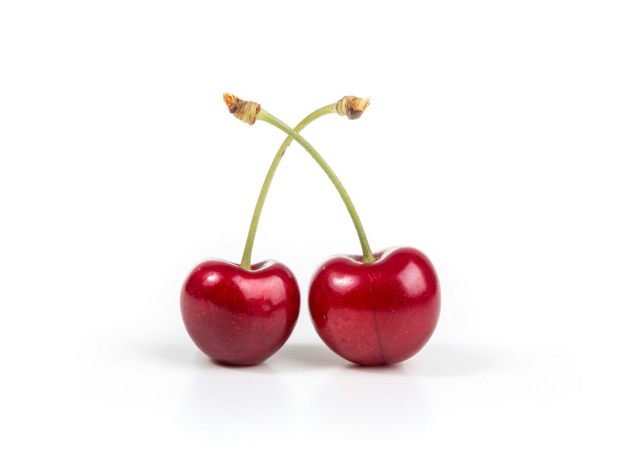 two cherries on white surface